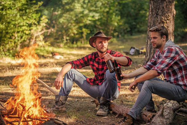 Just A Camp. spend free time together. family camping. hiking adventure. picnic in tourism camp. happy men brothers. friends relaxing in park together. drink beer at picnic. campfire life story - Foto, afbeelding