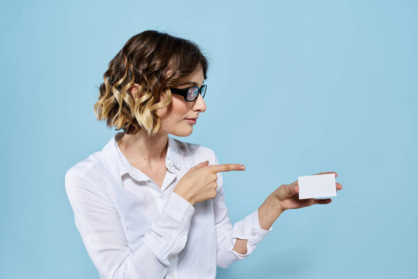 Mujer con gafas de tarjeta de visita en las manos sobre fondo azul Copiar espacio recortado ver - Foto, imagen