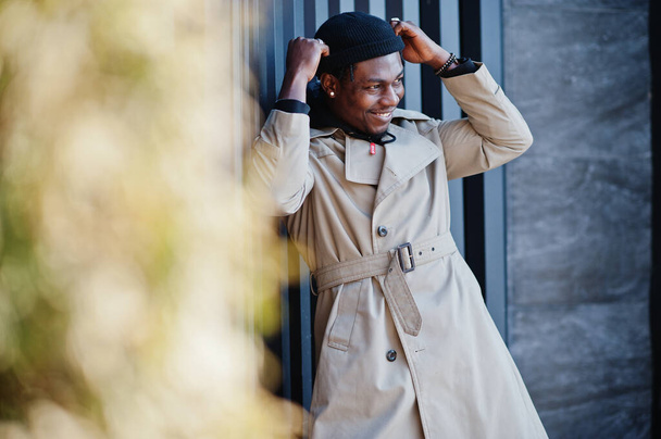 Handsome african american man posing outside in black hat and beige coat. - Φωτογραφία, εικόνα