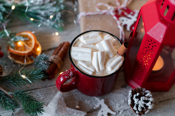 Boisson chaude d'hiver, cacao avec guimauves et cannelle ou chocolat chaud épicé en tasse rouge et guirlande de Noël. Festive fond vintage. - Photo, image
