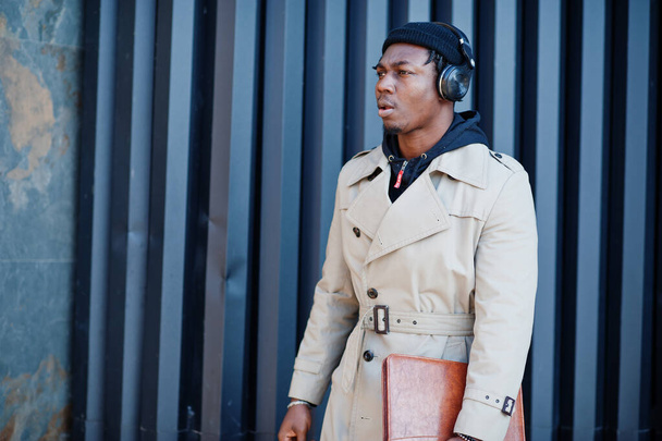 African american man with headphones, wear on hat and coat listening music on steel background. - Valokuva, kuva