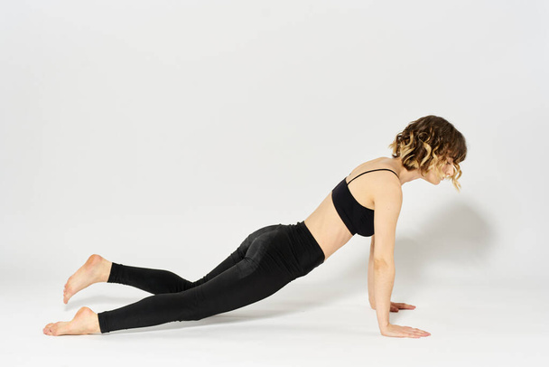 Donna sportiva farà l'esercizio sdraiato sul pavimento Ginnastica fitness in una stanza luminosa - Foto, immagini