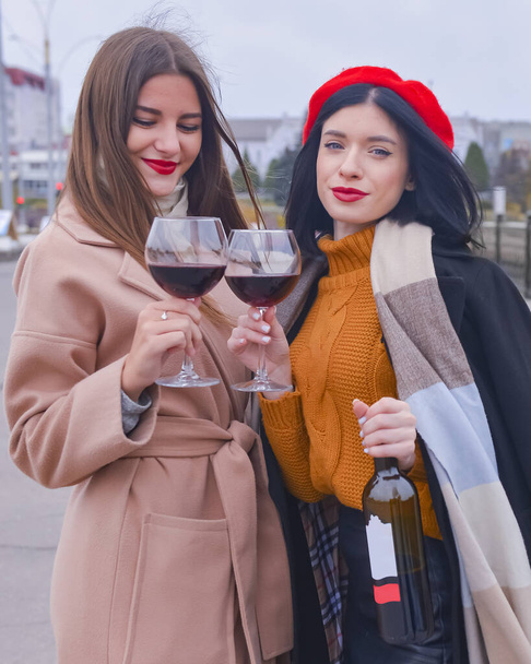 Two pretty cheerful women with glasses of wine outside. Leisure time, still life, eating out concept. - Foto, Imagen