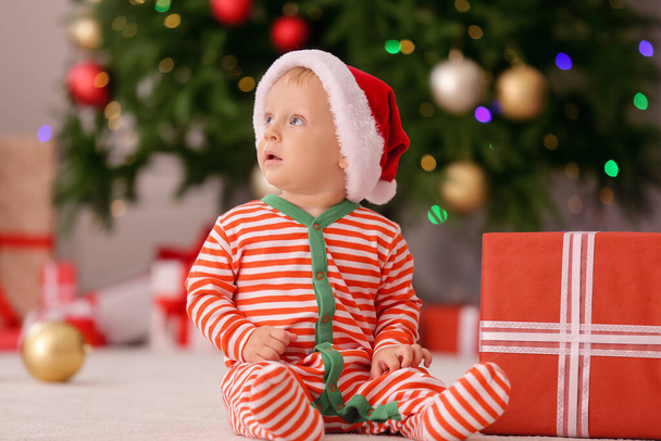 Noel Baba şapkalı şirin küçük bebek ve evde Noel hediyesi - Fotoğraf, Görsel