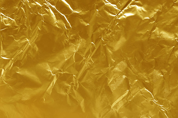 Χρυσό φύλλο φύλλο γυαλιστερή υφή, αφηρημένο κίτρινο χαρτί περιτυλίγματος για φόντο και το έργο τέχνης του σχεδιασμού. - Φωτογραφία, εικόνα