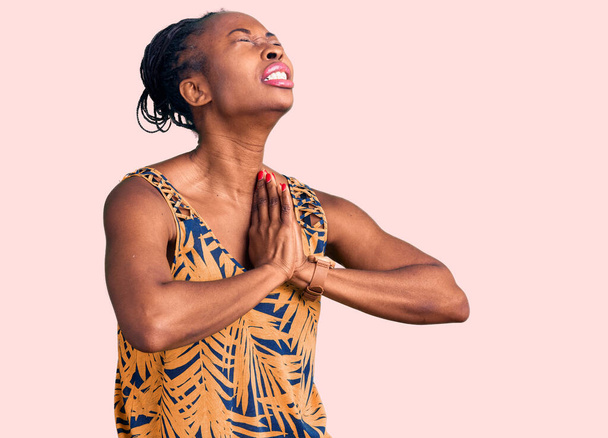 Jonge Afro-Amerikaanse vrouw draagt casual kleding bedelen en bidden met de handen samen met hoop uitdrukking op het gezicht zeer emotioneel en bezorgd. bedelen.  - Foto, afbeelding