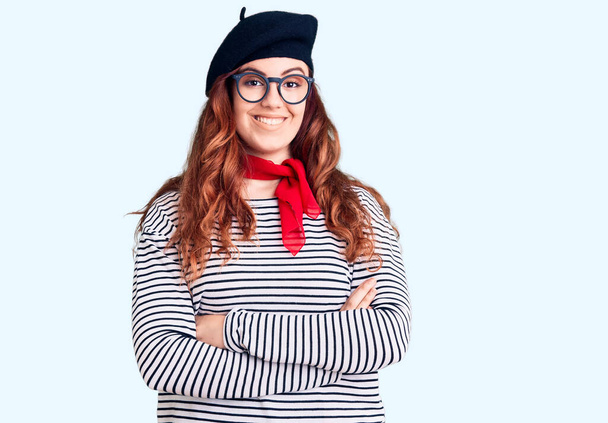 Young beautiful woman wearing french look with beret happy face smiling with crossed arms looking at the camera. positive person.  - 写真・画像