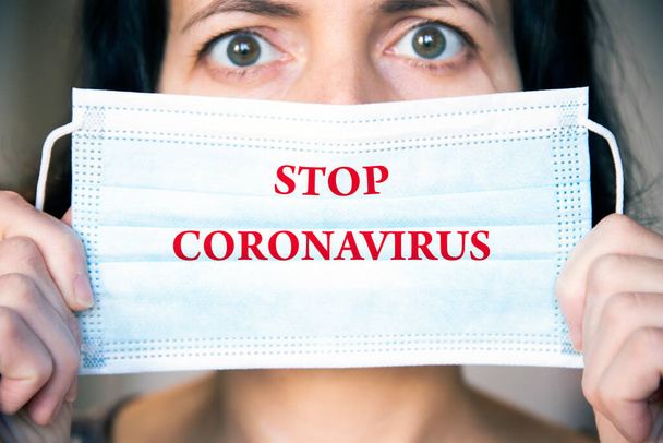Woman wearing medical protective surgical face mask with text Stop coronavirus. Concept of protection against Covid-19, coronavirus outbreak campaign. - Fotó, kép
