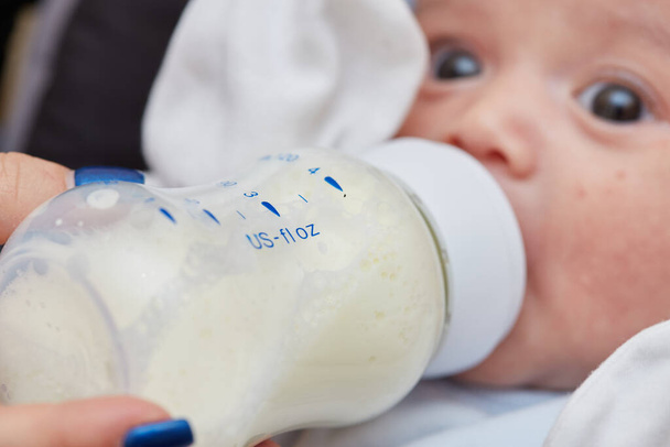 2-month-old newborn baby close-up . there is baby food, milk from a bottle. small depth of focus area . selective focus. - Photo, Image