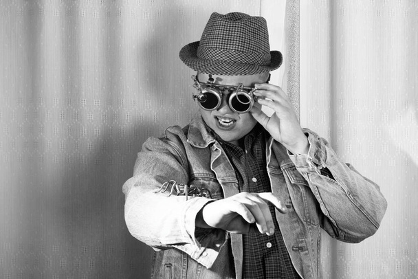 Чоловік в окулярах і капелюсі дивиться на павука, що сидить на руці, стиль стімпанк, чорно-біле фото
 - Фото, зображення