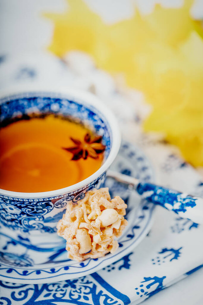 Egy csésze citromos tea ánizs csillaggal, mogyorós süti, fehér és kék ételek. Fénymásolási hely - Fotó, kép