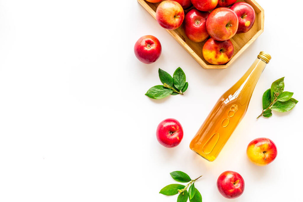 Top view of apple cider or vinegar - bottle with ripe fruits and leaves - Fotografie, Obrázek