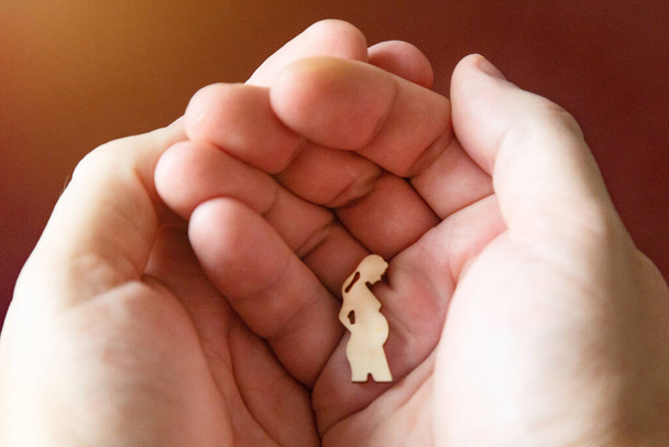 Silhouette figure of pregnant woman lies man's hand. - Foto, imagen