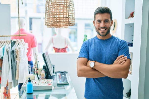 Junger gutaussehender Ladenbesitzer lächelt glücklich vor Bekleidungsgeschäft - Foto, Bild