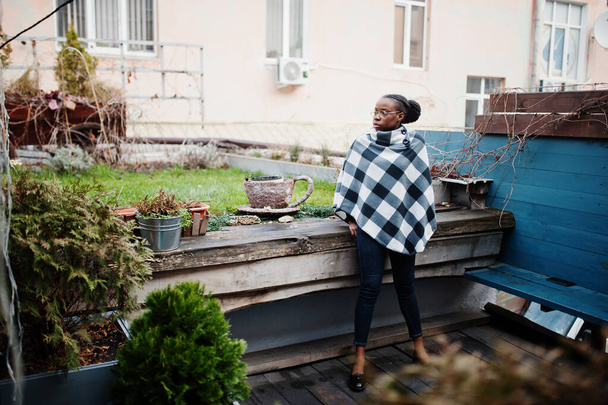 African woman in checkered cape posed outdoor. - Foto, Bild