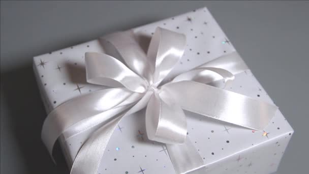Eingewickelte graue Geschenkboxen mit weißem Band auf grau - Filmmaterial, Video