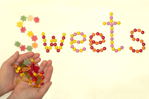Hafif arkaplanda renkli şekerlemelerle dolu bir kelime - Fotoğraf, Görsel