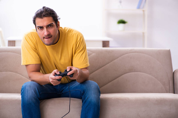Nuori mies pelaa joystick pelejä kotona - Valokuva, kuva