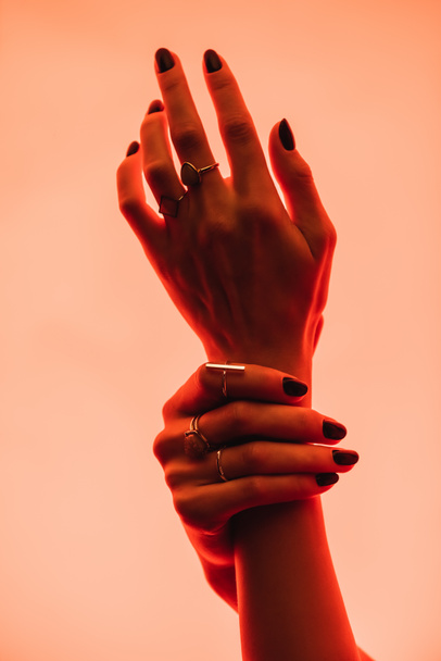 partial view of female hands with rings on fingers on pink  - Foto, Imagem