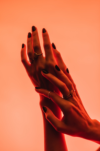 частичный вид женских рук с серебряными кольцами на пальцах на розовом  - Фото, изображение