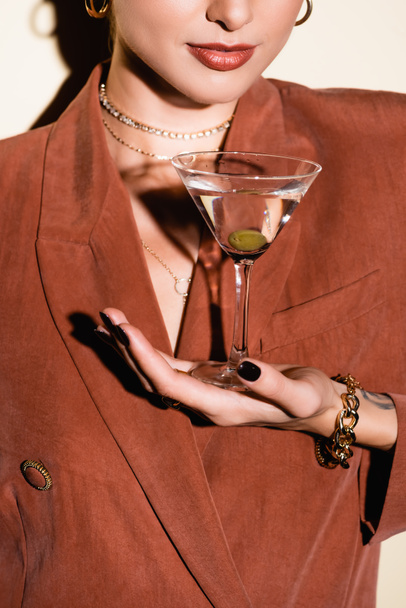 cropped view of woman holding glass of martini with olive on white - Fotoğraf, Görsel