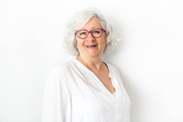 A Senior woman studio isolated on grey wall laughing cheerful - Zdjęcie, obraz