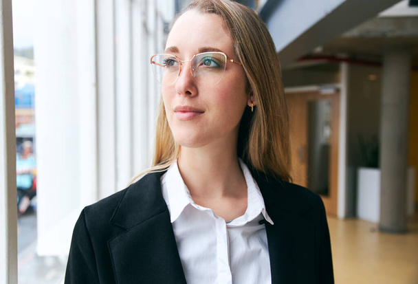 Retrato de una joven empresaria con gafas en una oficina moderna durante la pandemia de salud - Foto, imagen