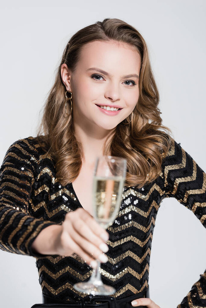 radosna kobieta trzymająca kieliszek szampana na niewyraźnym pierwszym planie  - Zdjęcie, obraz