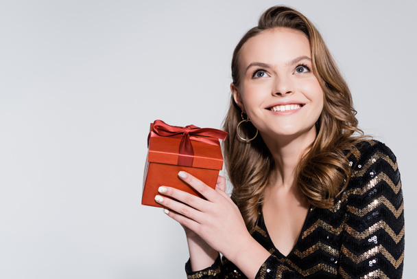 positive woman holding christmas present isolated on grey  - Foto, immagini