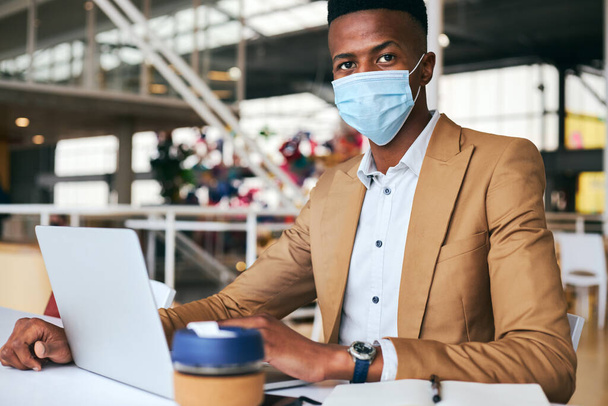 Retrato del hombre de negocios que usa máscara que trabaja en el ordenador portátil en el escritorio caliente en la oficina durante la pandemia de la salud - Foto, Imagen