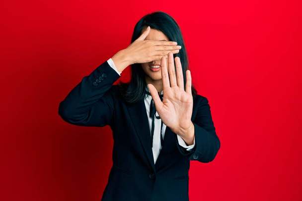 Beautiful asian young woman wearing business suit covering eyes with hands and doing stop gesture with sad and fear expression. embarrassed and negative concept.  - Foto, immagini