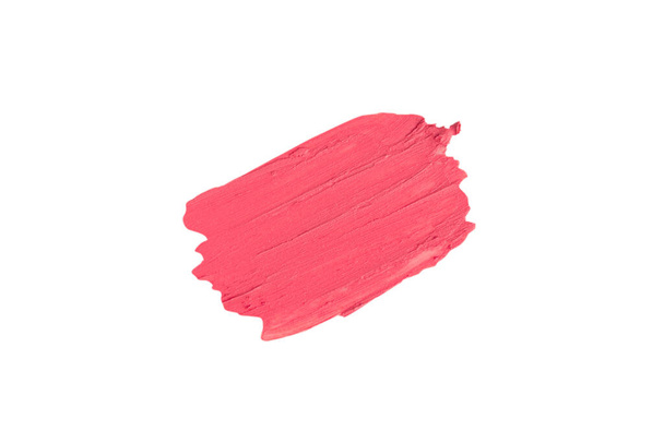 Rojo-rosa aislado Swatch de lápiz labial sobre un fondo blanco. Una mancha de maquillaje. La base para el maquillaje tiene una textura cremosa. - Foto, Imagen