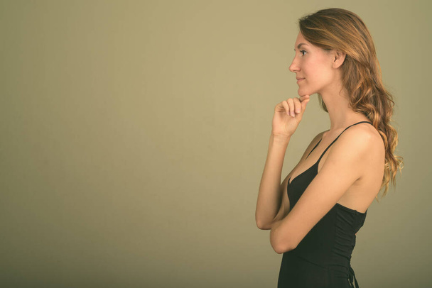 Jonge mooie vrouw dragen mouwloze top tegen gekleurde achtergrond - Foto, afbeelding