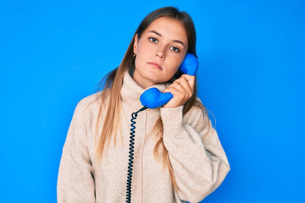 Beautiful caucasian woman speaking on vintage telephone thinking attitude and sober expression looking self confident  - Photo, Image