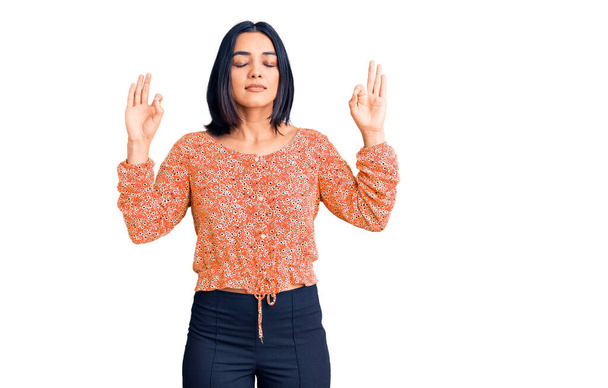 Young beautiful latin woman wearing casual clothes relax and smiling with eyes closed doing meditation gesture with fingers. yoga concept.  - Фото, изображение