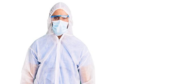Fiatal spanyol férfi orvos védő koronavírus egyenruhát visel, orvosi maszk depressziós, és aggódik a szorongás, sír dühös és fél. szomorú kifejezés.  - Fotó, kép