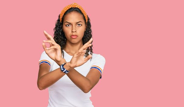 若いアフリカ系アメリカ人の女の子を着てカジュアルな服を拒否表現交差腕や手のひら負の記号を行う、怒っている顔  - 写真・画像