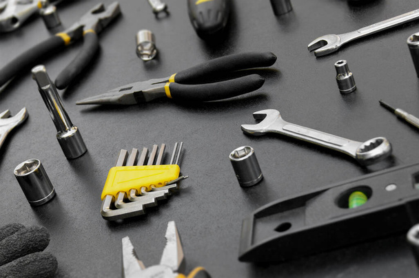 Muchas herramientas diferentes para trabajos de reparación sobre un fondo negro. Concepto de reparación y construcción. - Foto, imagen