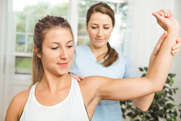 A Modern rehabilitation physiotherapist at work with client - Foto, Bild