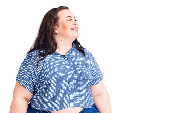 Young plus size woman wearing casual clothes looking away to side with smile on face, natural expression. laughing confident.  - Foto, afbeelding