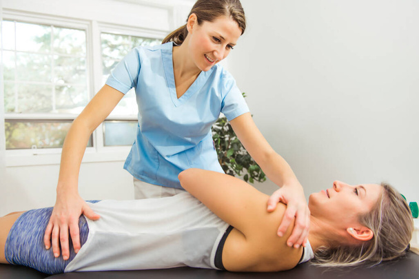A Modern rehabilitation physiotherapist at work with client - Fotoğraf, Görsel