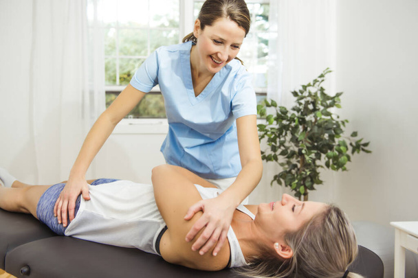 A Modern rehabilitation physiotherapist at work with client - Foto, Imagen
