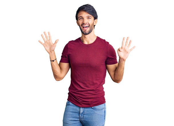 Hezký hispánec v neformálním oblečení ukazující a ukazující s prsty číslo devět a usmívající se sebevědomě a šťastně.  - Fotografie, Obrázek