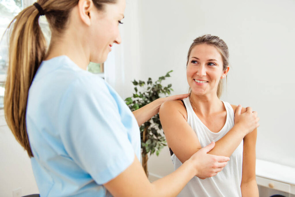 A Modern rehabilitation physiotherapist at work with client - Foto, imagen