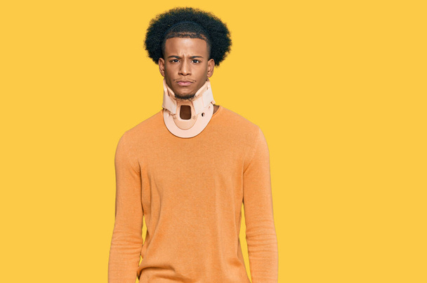 African american man with afro hair wearing cervical neck collar skeptic and nervous, frowning upset because of problem. negative person.  - Photo, image