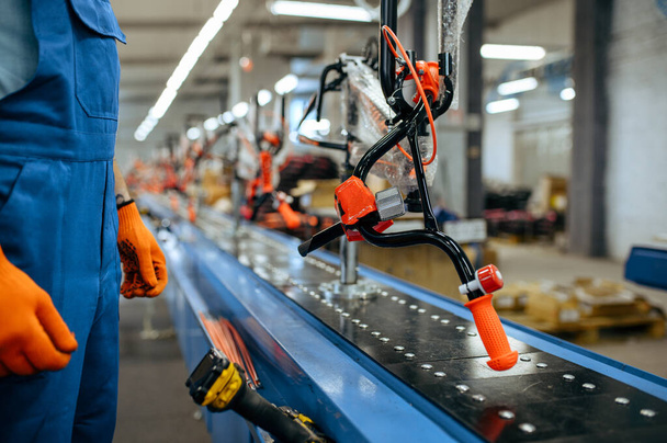 Fahrradfabrik, Arbeiter überprüft Fahrrad-Fließband. Mechaniker in Uniform montiert Fahrradteile in Werkstatt, industrielle Fertigung - Foto, Bild