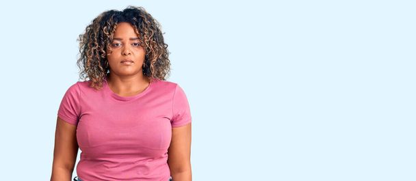 Young african american plus size woman wearing casual clothes relaxed with serious expression on face. simple and natural looking at the camera.  - Foto, Imagen