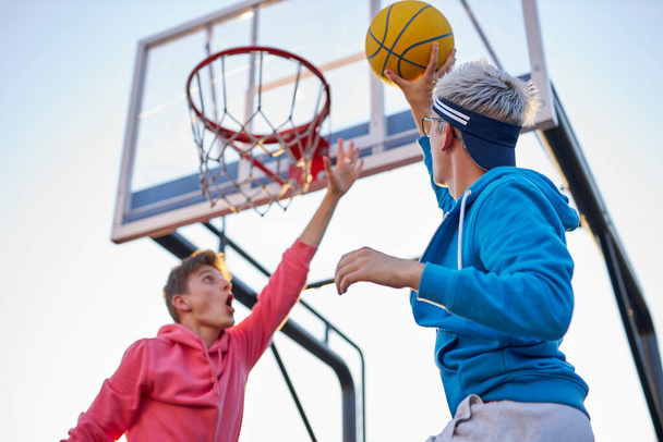 teens shooting basket and playing basketball, lower view wide angle - Foto, immagini