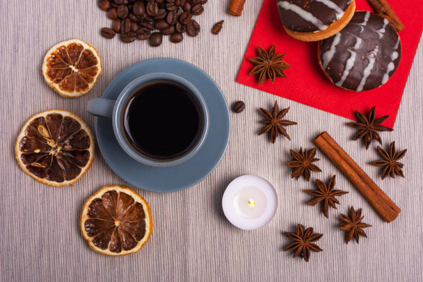 Una taza de espresso está decorado con estrellas de anís, canela, dulces, limones secos, bellotas, cacahuetes en un hermoso plato. - Foto, imagen