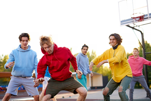 group of young male teenagers playing basketball outdoors - Foto, Bild